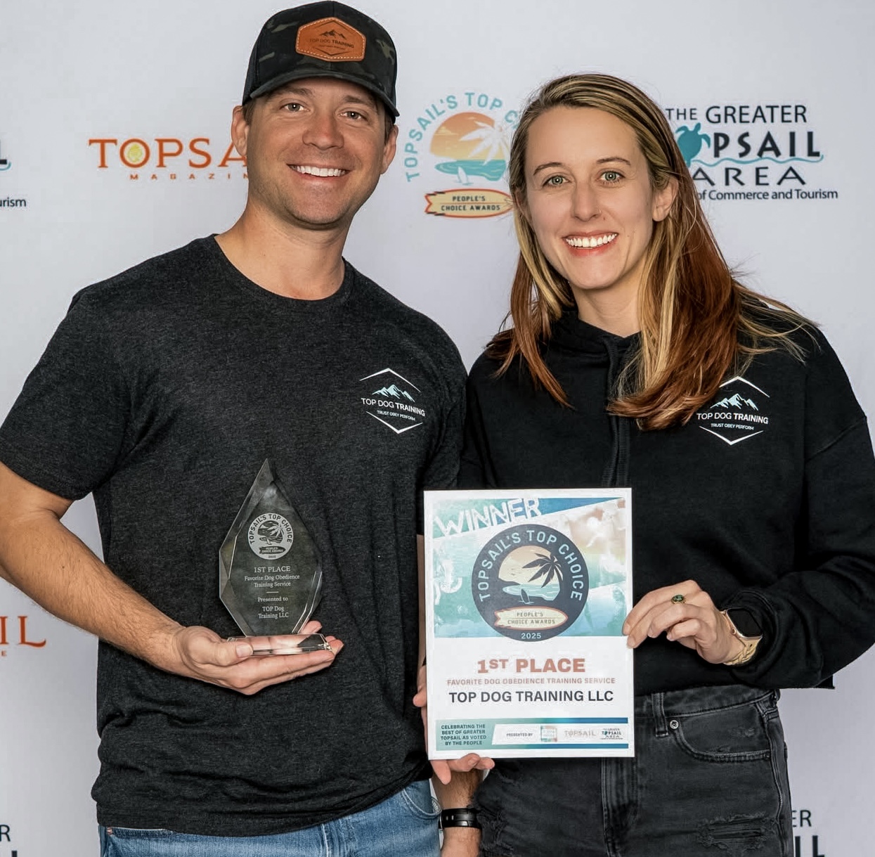 Ryan Loseke and Breanna Anderson holding TOP Dog Training's 2025 Topsail Top Choice first-place trophy and certificate for Favorite Dog Obedience Training Service